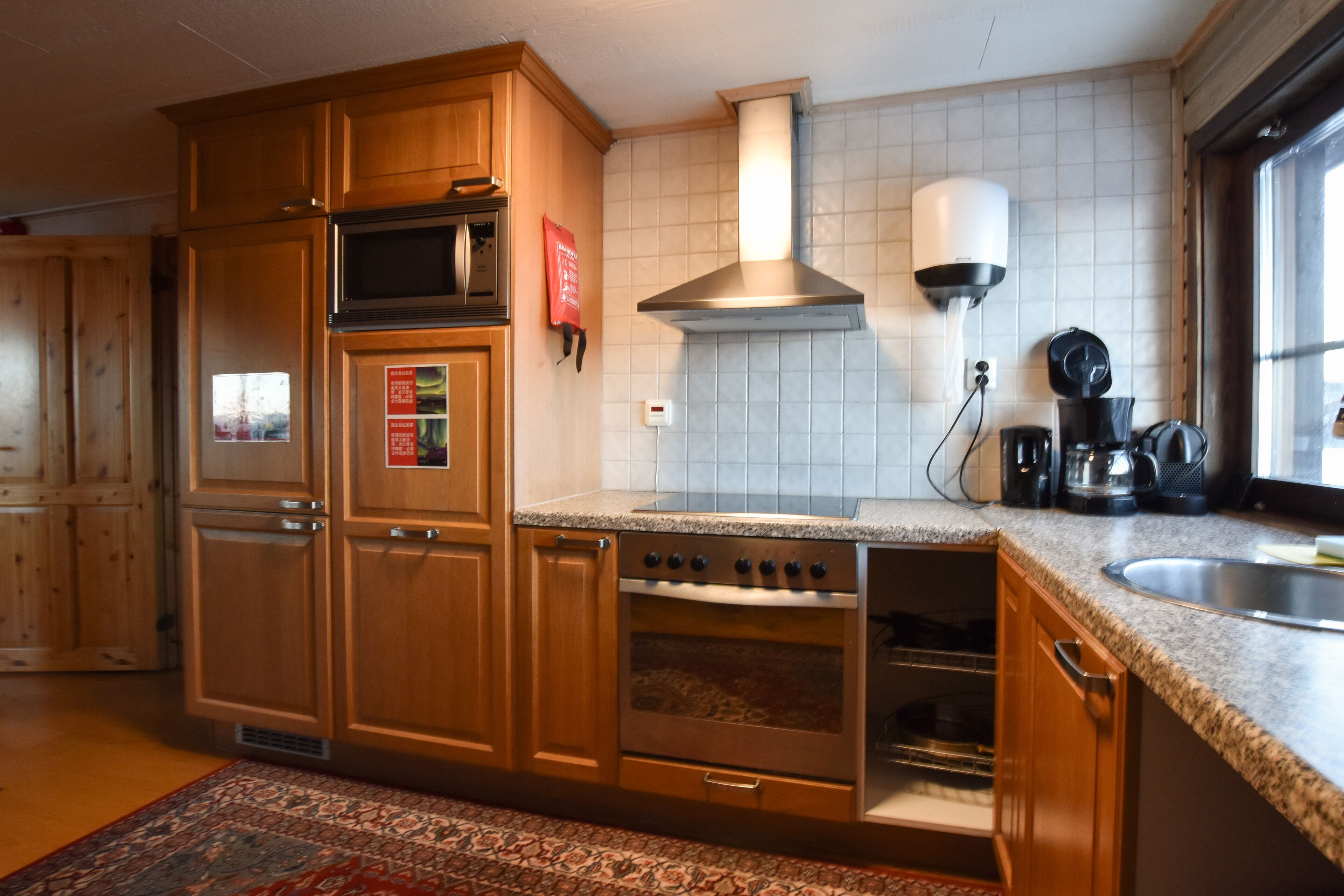 A kitchen with wooden cabinets, a built-in oven, a microwave, and a stove.