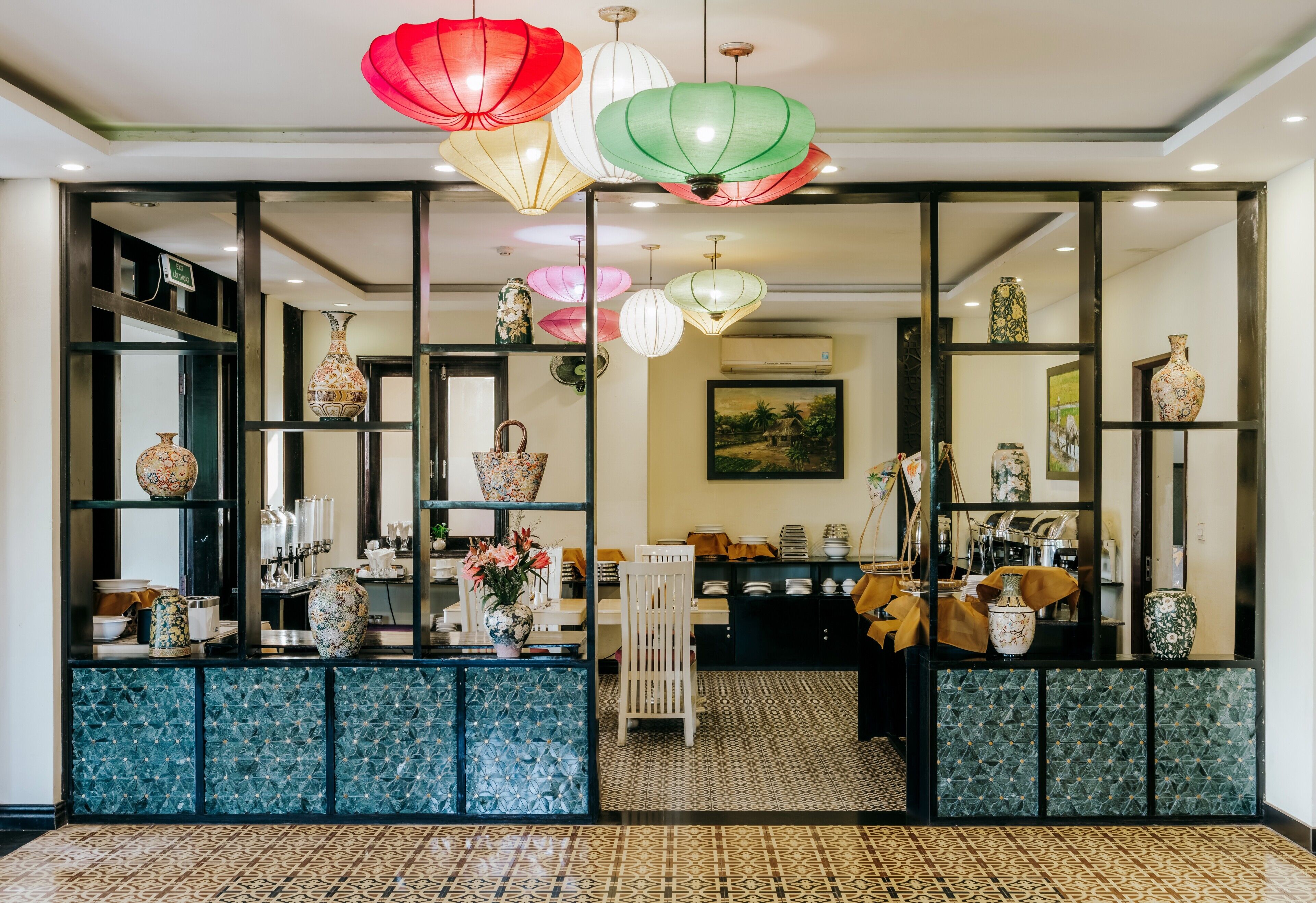 A reception area with a counter, shelves with decorative items, and hanging paper lanterns.