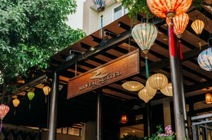 A sign for 'River Suites' with hanging lanterns and a metal structure.