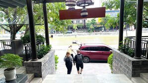 A staircase leading to a building entrance with a red car parked outside. - River Suites Hoi An Hotel (Da Nang)