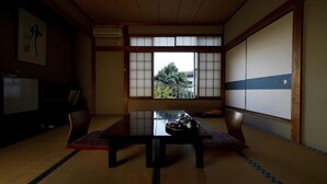 Ein traditioneller japanischer Raum mit Tatami-Böden, einem niedrigen Tisch und Shoji-Schiebetüren.
