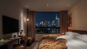 A hotel room with a city view, a desk with a chair, a bed with white linens, and a large window with curtains. - HYATT - EPISODE Daan Taipei, jdv by Hyatt (Taipei)