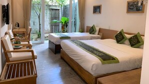 A hotel room with two beds, a wooden bench, a desk, and a view of the outdoors. - Jolie Villa Hoi An (Da Nang)