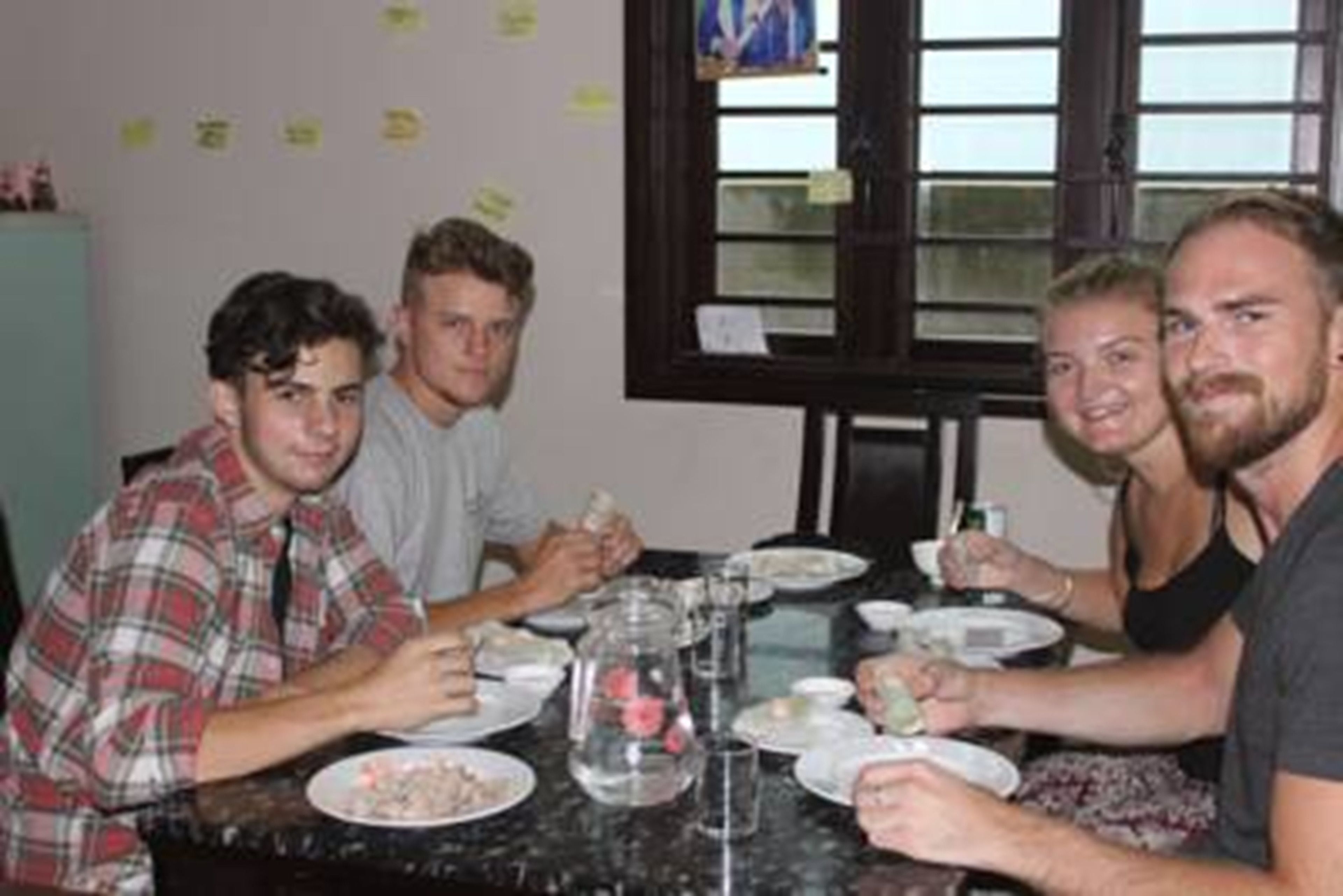 A group of people dining at a table with various dishes and glasses.
