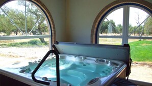 A hot tub with a view of a park through large windows. - Monte das Faias (Grandola)