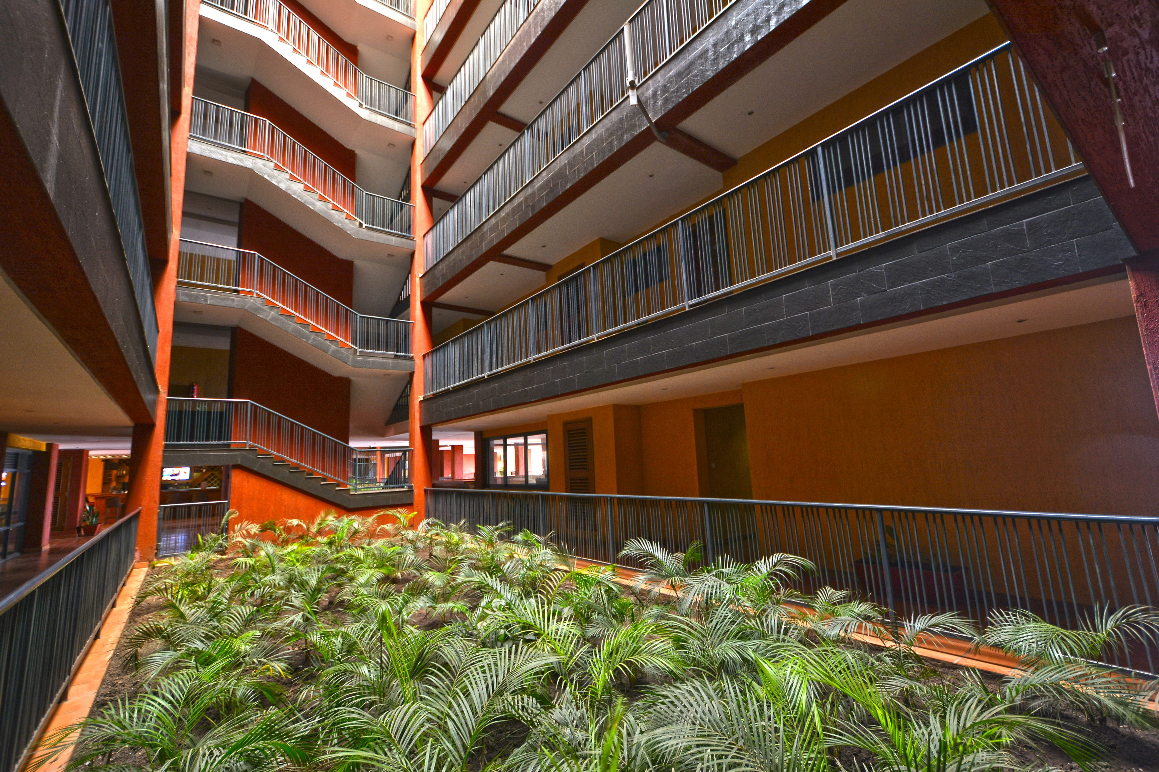 A multi-level atrium with a central garden area featuring various plants.