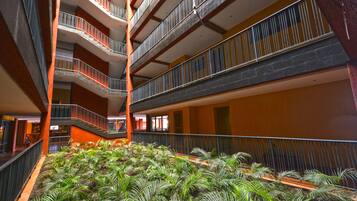 A multi-level atrium with a central garden area featuring various plants.