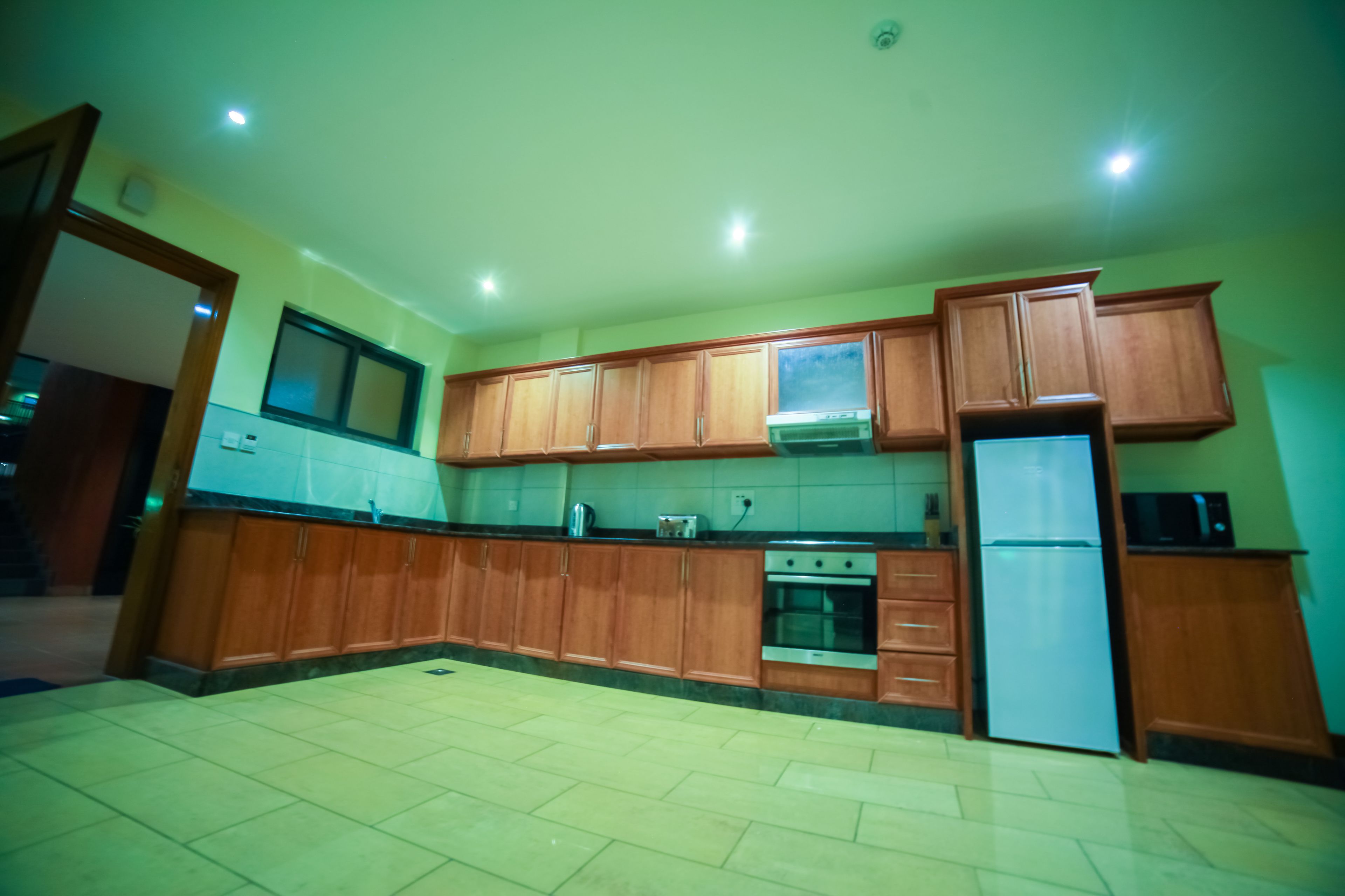 A kitchen with wooden cabinets, a refrigerator, and a stove.