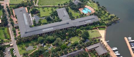 Vista aérea de un resort con un edificio grande, una piscina y un puerto deportivo.