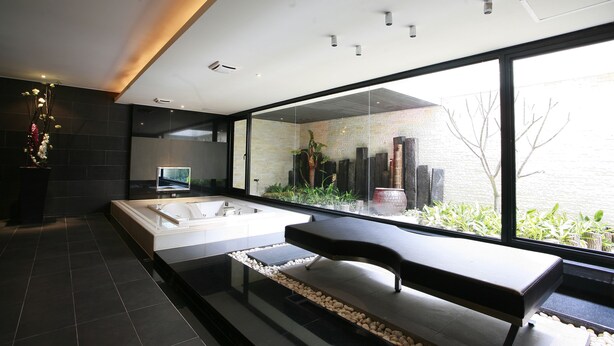 A modern bathroom with a large bathtub, a bench, and a view of the outdoors. - Yes Motel City Resort Paradise (New Taipei City)