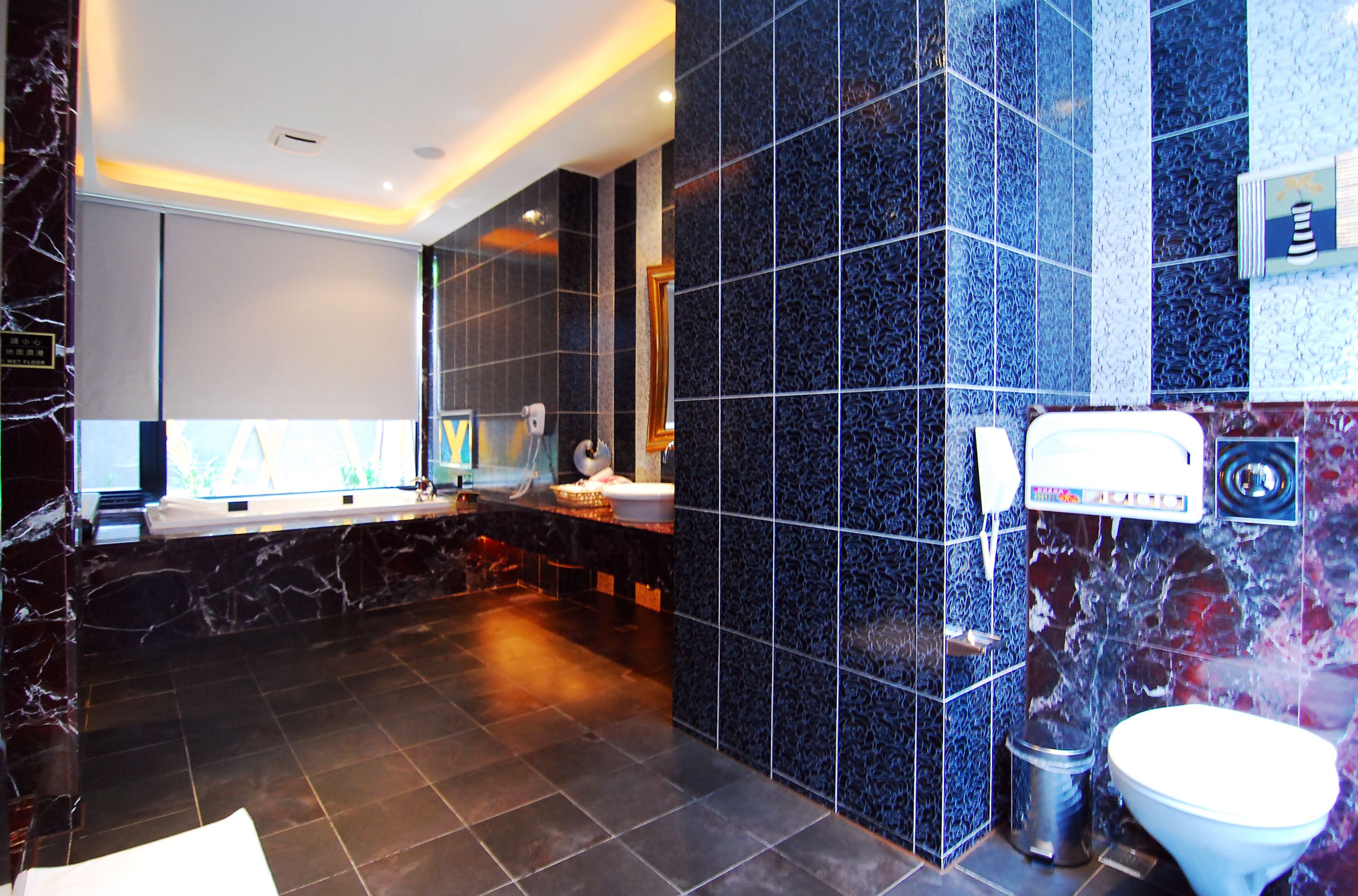 A modern bathroom with a marble vanity, a large mirror, and a toilet.