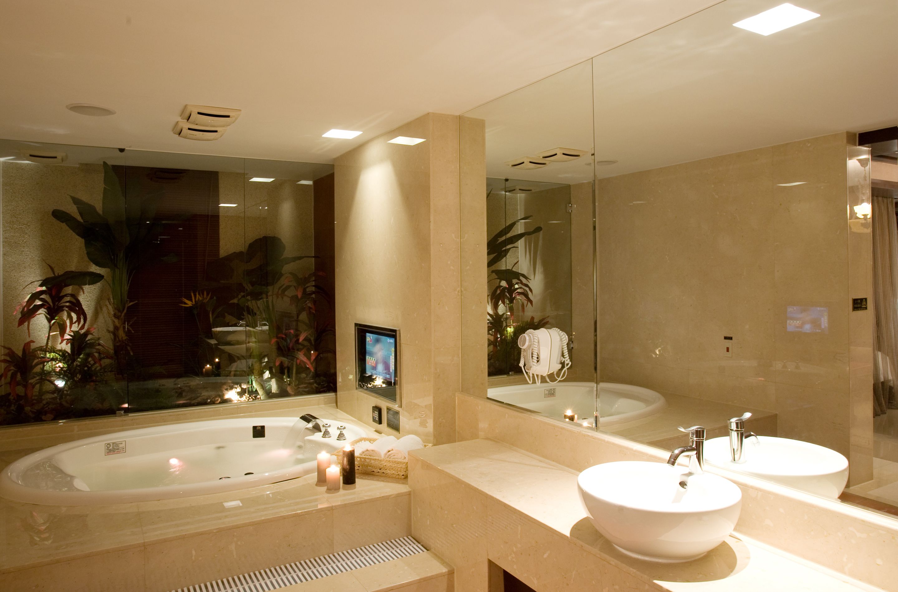 Un baño moderno con una bañera grande, dos lavabos y un espejo amplio.