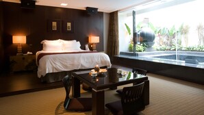 A hotel room with a bed, bedside lamps, a table with chairs, and a view of a garden through a large window. - Yes Motel City Resort Paradise (New Taipei City)
