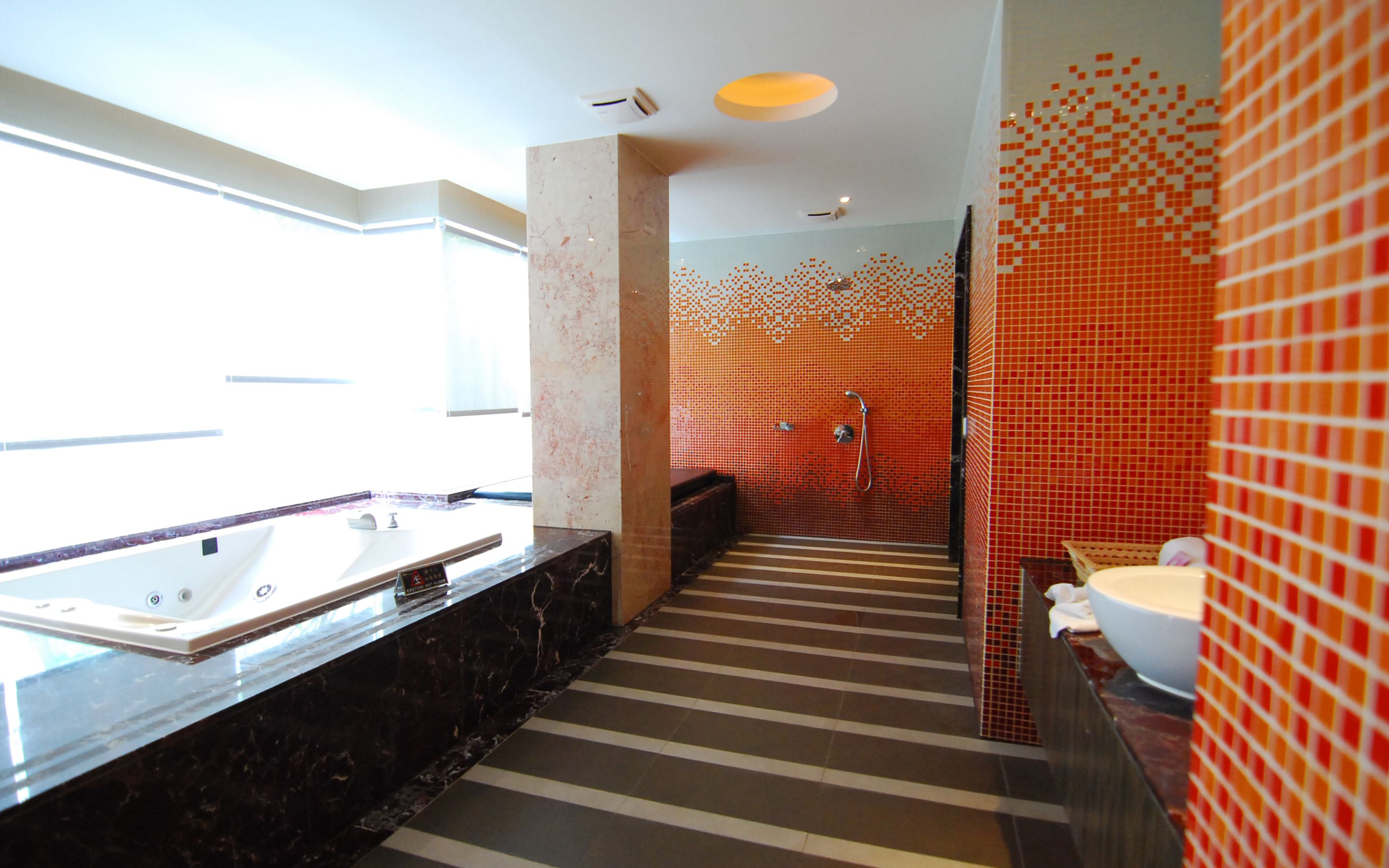 A modern bathroom with a large bathtub, a separate shower area, and a vanity with a sink.