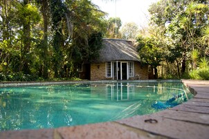 Una piscina al aire libre, sillones reclinables de piscina
