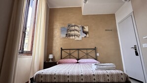 Ein Schlafzimmer mit einem Bett, einer Chandelierleuchtre, einer Wandklimaanlage und einem fenster mit Vorhängen.