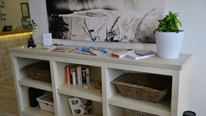 Mostrador de recepción con planta, revistas y cestas.