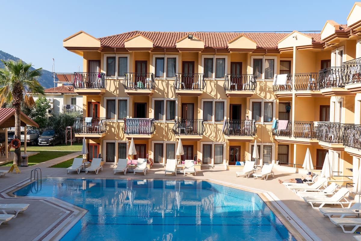 Un hôtel doté d’une piscine, de plusieurs balcons et de chaises longues.