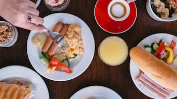 A table with various dishes including sausages, bread, and a dessert.