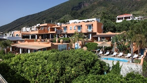 Un complejo turístico con varias edificaciones, piscina y abundante vegetación.