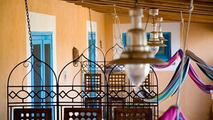 Una habitación con una hamaca, un enrejado metálico decorativo y un techo de madera.