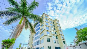 Un hôtel à plusieurs étages au design moderne, reconnaissable à son enseigne bien visible indiquant « Turquoise Hotel ».
