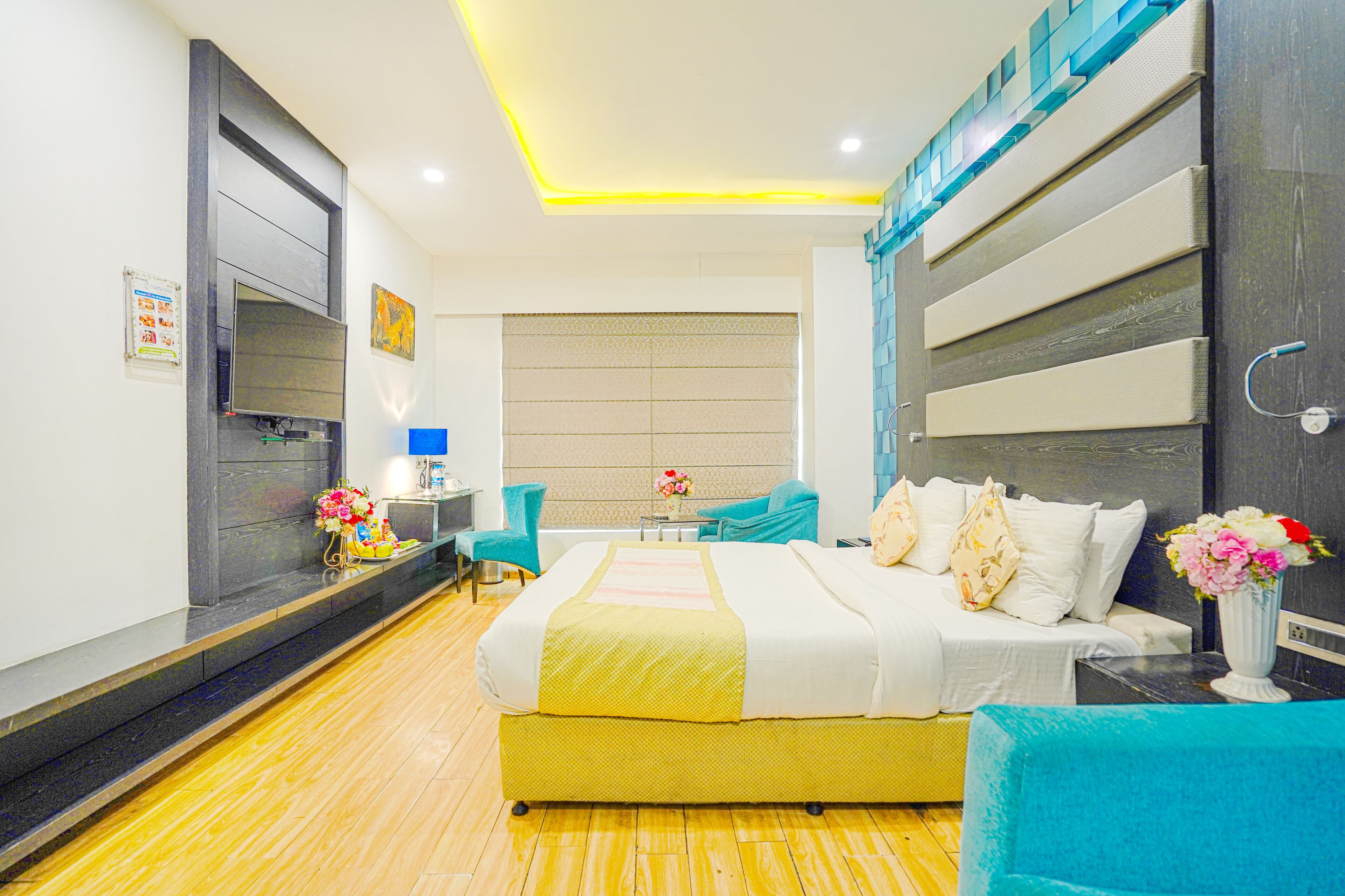 A modern hotel room with a large bed, a desk, and a chair.