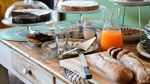 A breakfast buffet with various food items and a glass pitcher of orange juice.