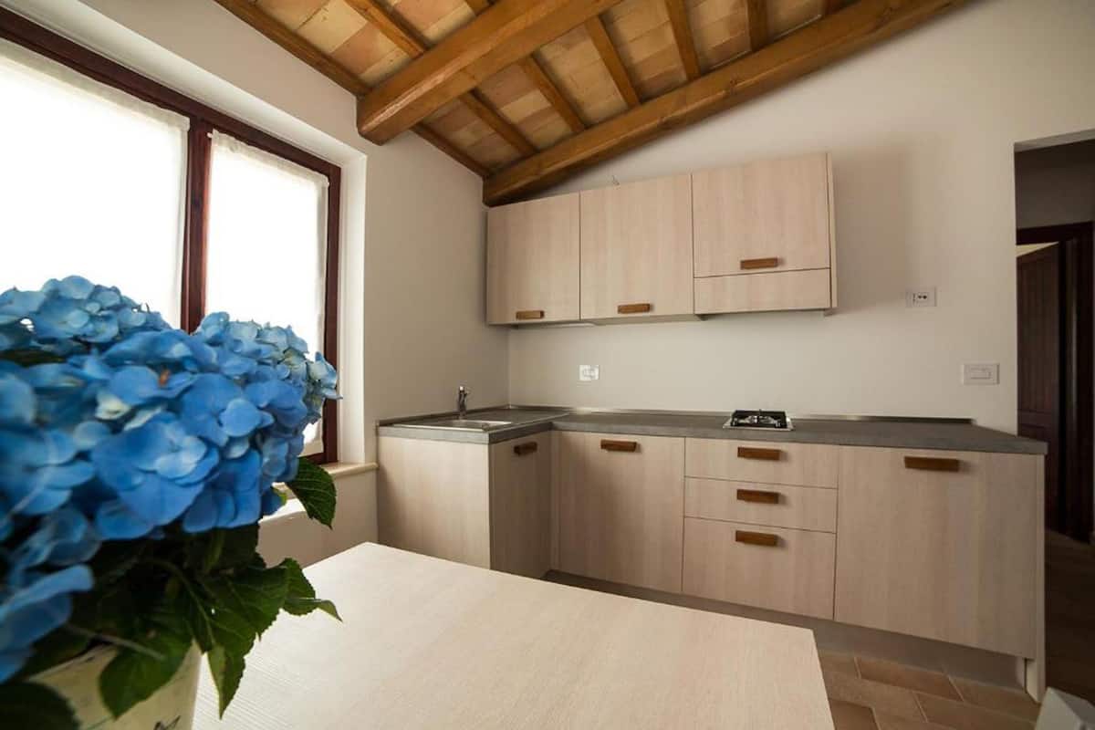 A kitchen with wooden cabinets, a sink, and a countertop.