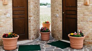 A courtyard with two brick towers, each with a wooden door and potted plants.