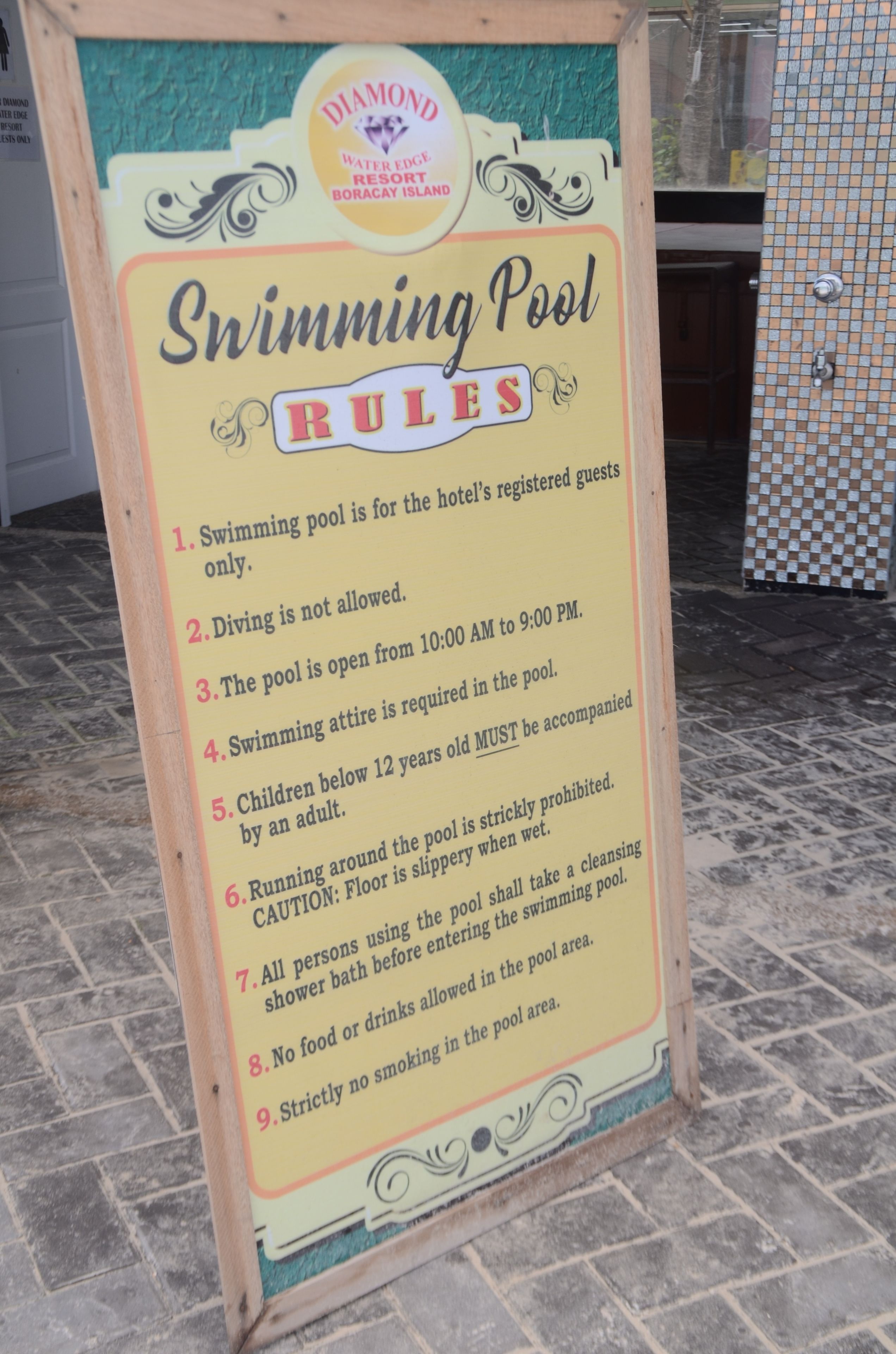 A sign listing the rules for a swimming pool at a hotel.