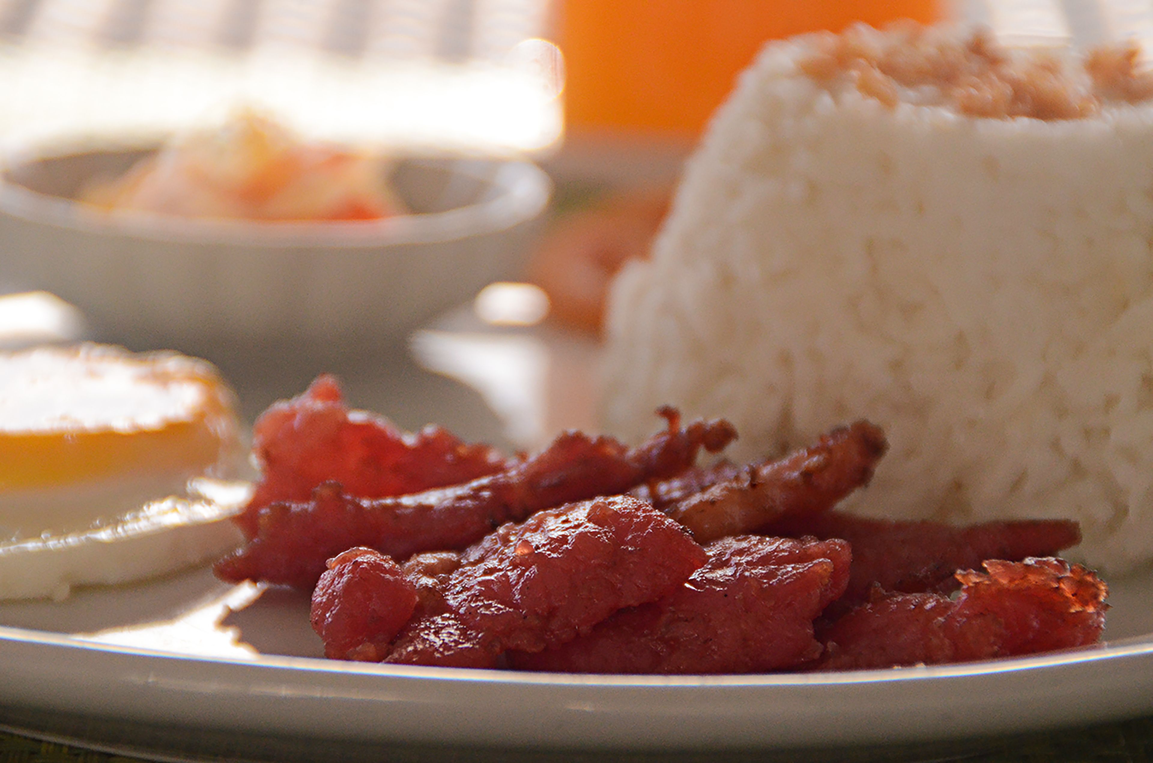 Un plato con arroz blanco, carne roja y un huevo cocido.