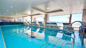 A swimming pool with clear blue water, lounge chairs, and a view of the sea. - Diamond Water Edge Resort (Boracay Island)