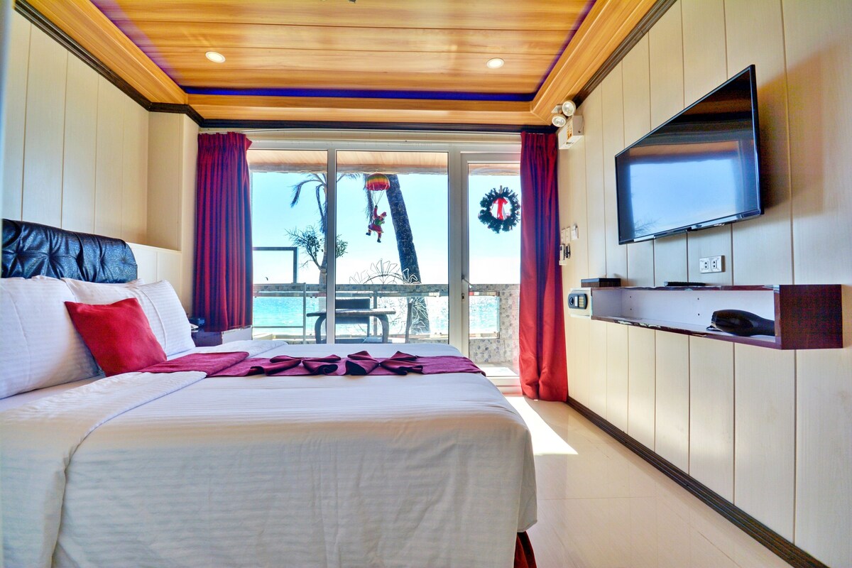 Habitación de hotel con cama, televisión y vistas al exterior.