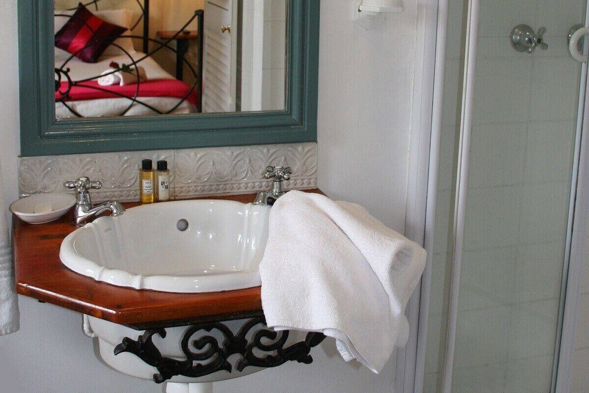 A bathroom with a white sink, a mirror, and a shower door.