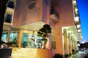 A modern hotel entrance with a large tree in the center, glass doors, and a staircase leading up to the entrance. - Alesta Yacht Hotel (Fethiye)
