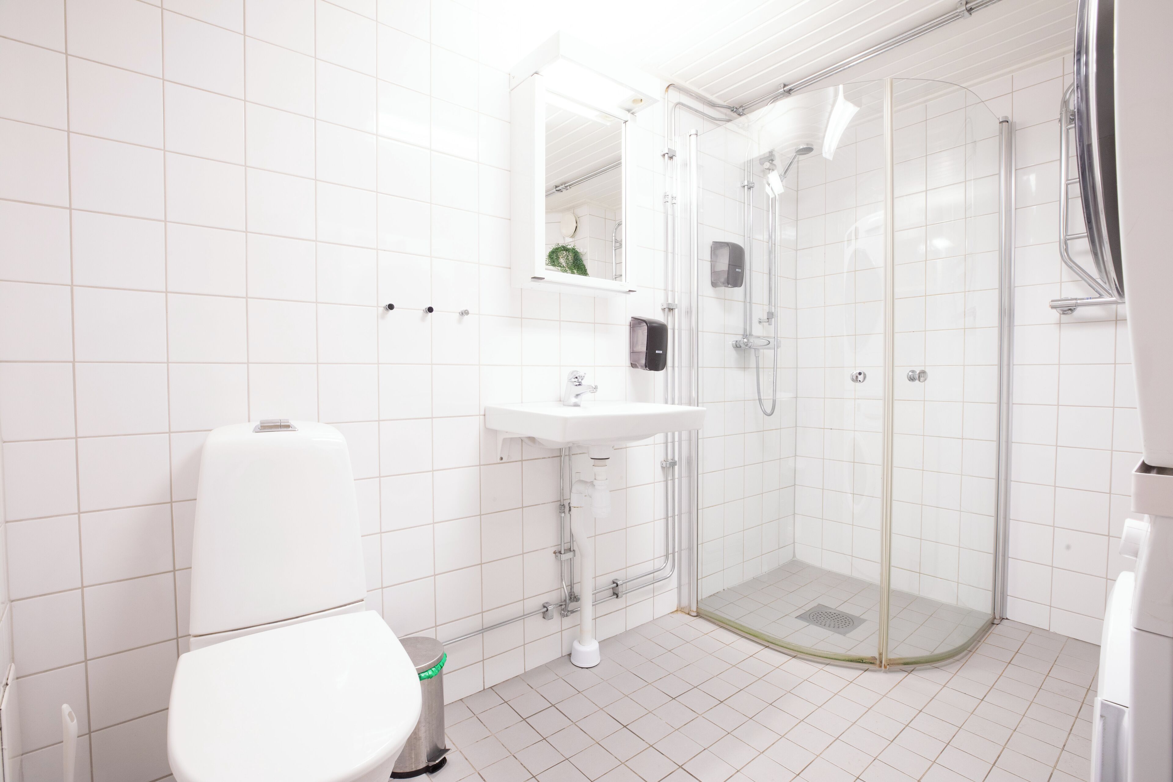 Un baño moderno con inodoro, lavamanos y ducha envuelta en vidrio.