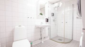Un baño moderno con inodoro, lavamanos y ducha envuelta en vidrio.