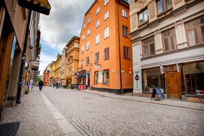 A cobblestone street lined with historic buildings, including a tattoo parlor and a restaurant. - ApartDirect Gamla Stan II (Stockholm)