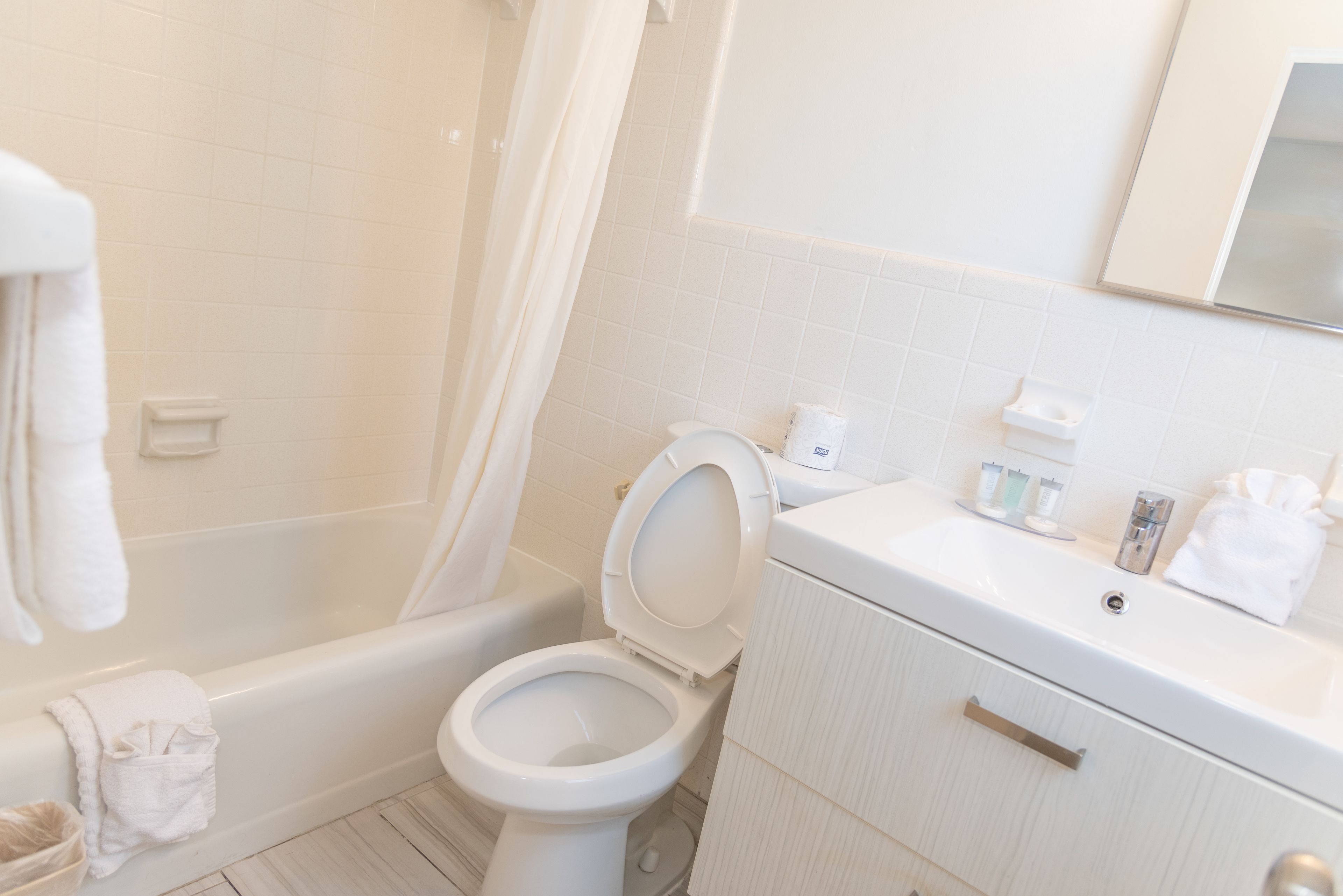 A bathroom with a bathtub, toilet, and sink.