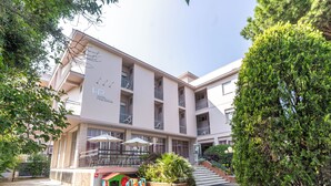Un hôtel doté d’un espace de jeux pour enfants, de sièges en plein air et d’un escalier menant à l’entrée.