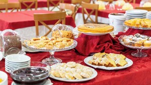 Un buffet proposant une variété de desserts et d’en-cas, disposés sur des tables recouvertes de nappes rouges.