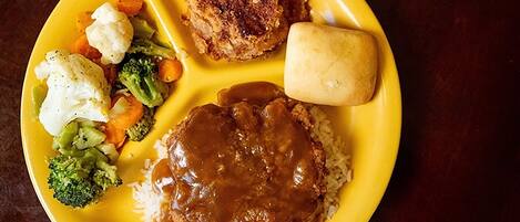 Two plates of food with a red and a yellow plate.