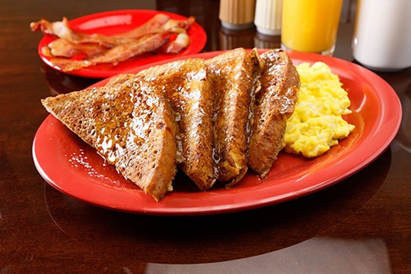 Um prato com carne grelhada, torradas e ovos mexidos.