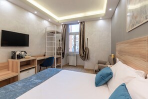 A modern hotel room with a bed, desk, chair, and a TV. - Drago D'oro Guesthouse (Rome)