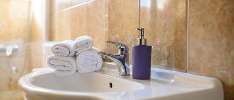 A bathroom sink with a towel dispenser and a toilet.