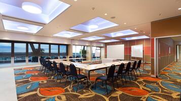 A conference room with a large table, chairs, and a whiteboard.