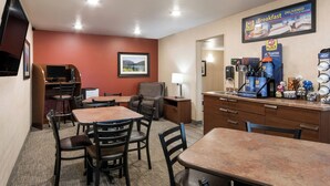A hotel room with a dining area, a coffee station, and a TV. - My Place Hotel - Ft. Pierre, SD (Fort Pierre)