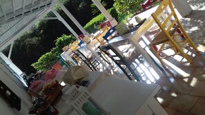 A covered outdoor area with tables and chairs, surrounded by greenery. - B&B A Casa di Joy (Lecce)