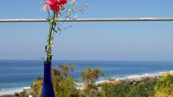 Una mesa con una jarra de cerveza, un libro y un florero con flores.